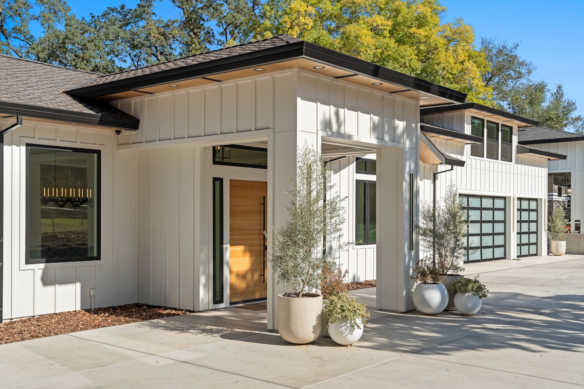 A modern farmhouse-style home exterior — white board-and-batten siding, black-framed windows, and enclosed soffits typical of updated homes throughout Lamorinda
